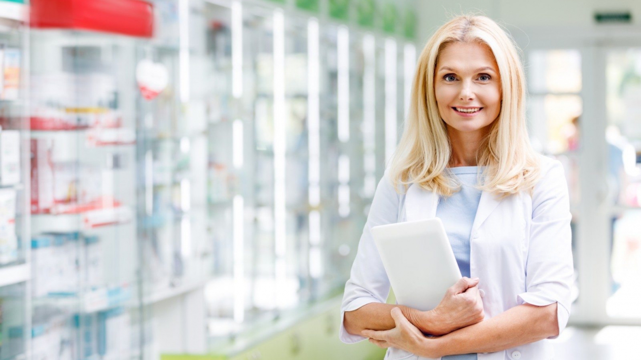 cheerful-pharmacist-holding-digital-tablet-and-smi-98L5GF6-1-min