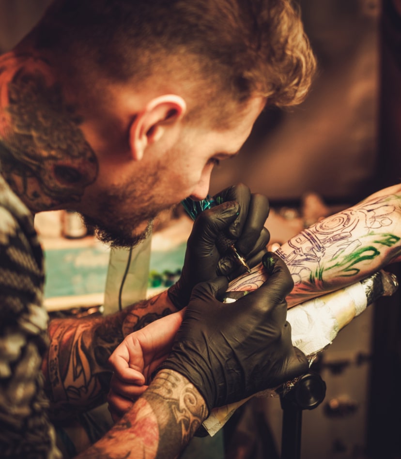 tattoo-artist-makes-a-tattoo-on-a-mans-hand-PECZRE223-min